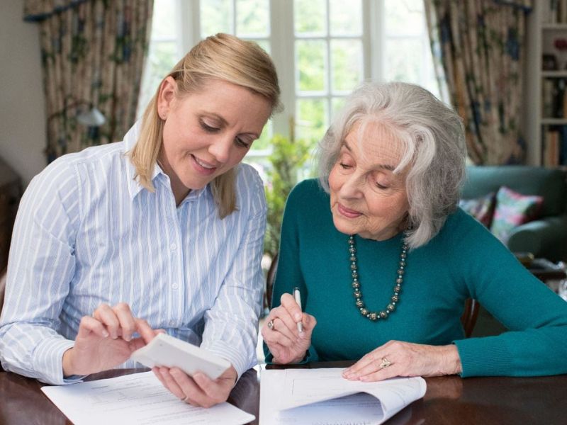 mother and daughter going over long term care policy paperwork