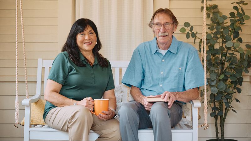 Home Instead caregiver sitting on porch swing with senior home care client in Lewisville, NC