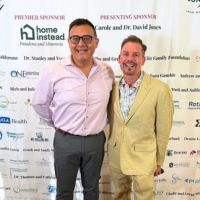 2 men in front of sign